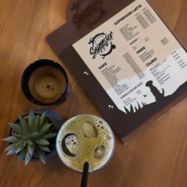 Superfood latte na stolu, pored menija sa znakom Snippstera